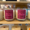 Candles labeled 'Sugar Plum Tea & Smoke' on a store shelf.
